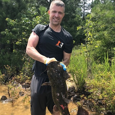 man holding flathead catfished that he noodled