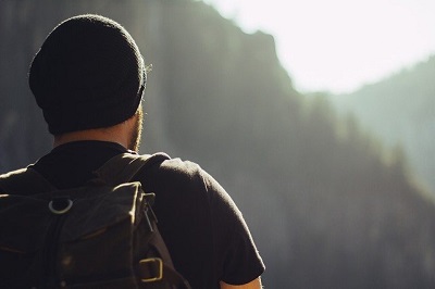 man with backpack on hike looking at horizon