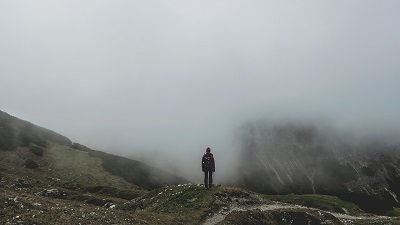 person hiking in foggy mountains