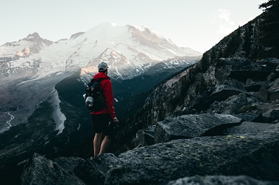 man hiking in mountains with gear