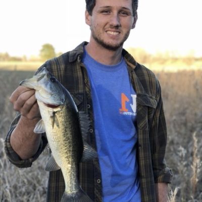 Cody Hall holding largemouth bass and wearing N1 Outdoors t-shirt
