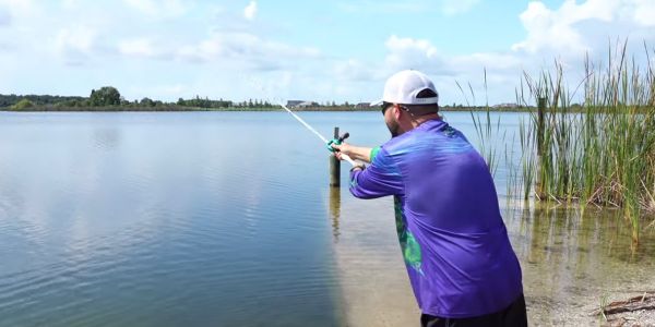 man casting bait caster and following through
