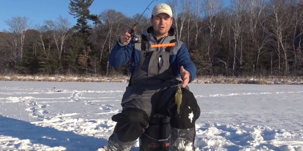 man holding bream caught while ice fishing