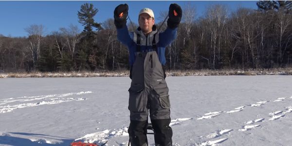man holding ice fishing safety spikes