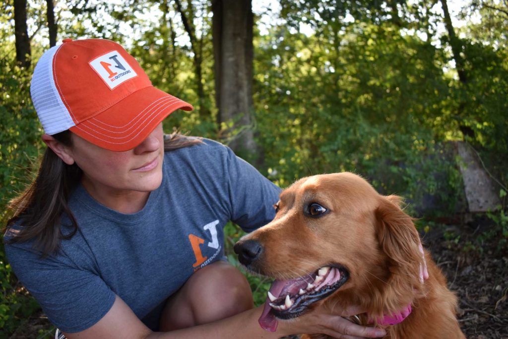 woman wearing n1 outdoors hat and shirt with dog