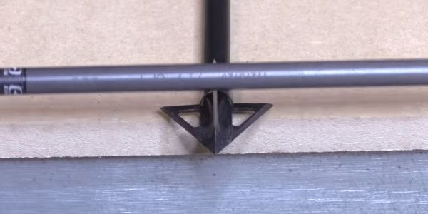 carbon shaft running across blade of tooth of the arrow broadhead