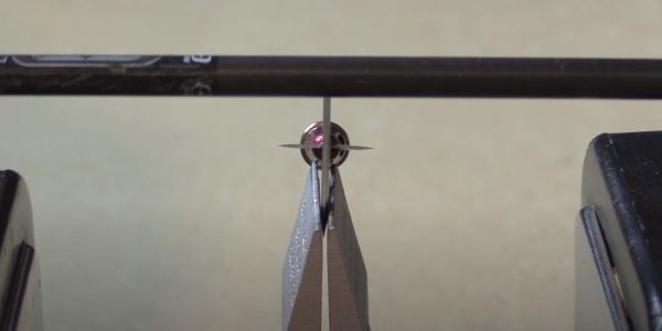 a carbon arrow shaft going over the blade of a dirt nap drt broadhead