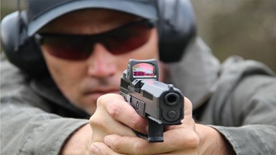 man shooting pistol with optical sight