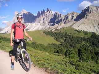 mountain-biker-standing-by-bike-in-mountains
