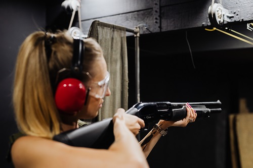 woman practicing shooting home defense shotgun