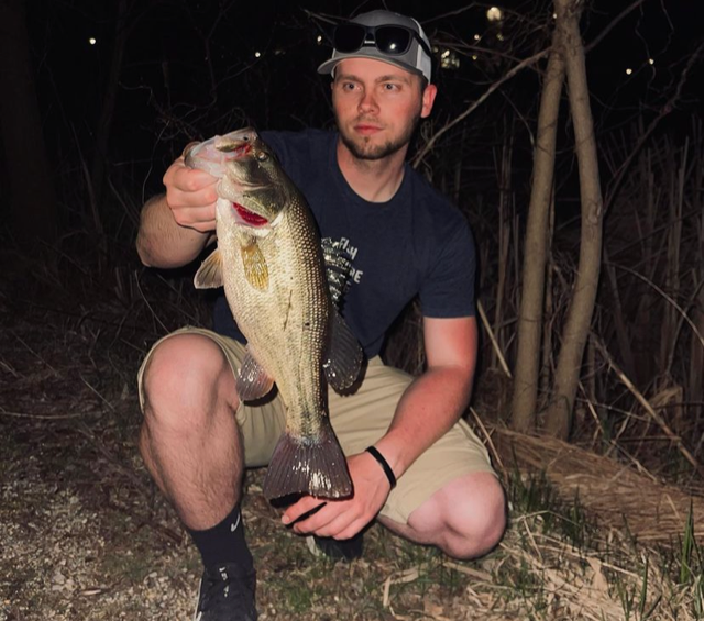 man holding bass at night