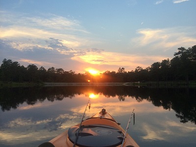 fishing kayak in water at sunrise