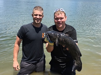 two men with a blue catfish