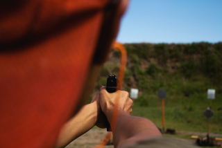 man shooting handgun on range