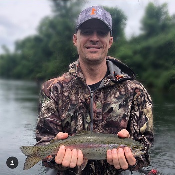 man wearing N1 Outdoors hat holding rainbow trout