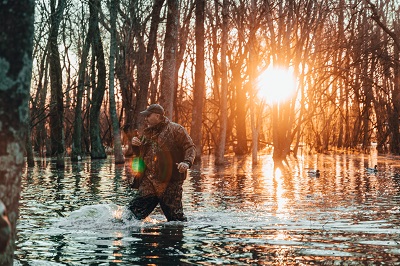duck hunter wading in water