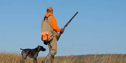 hunter in field with dog