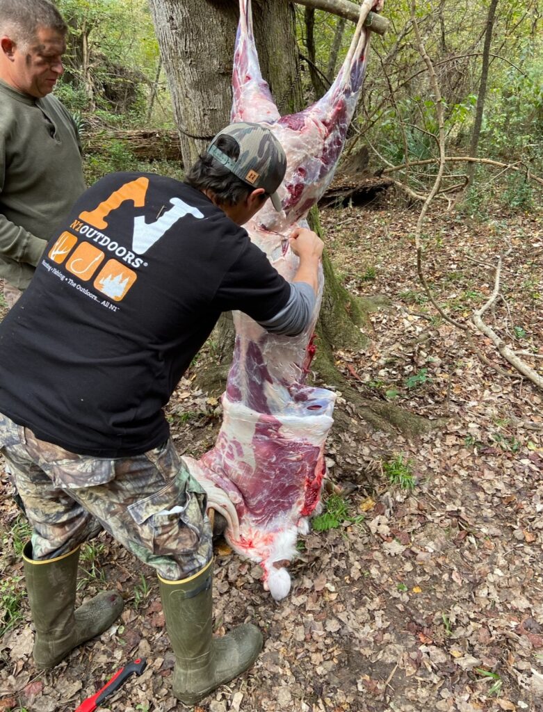 man cleaning deer with N1 shirt on