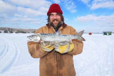 man holding fish from ice fishing