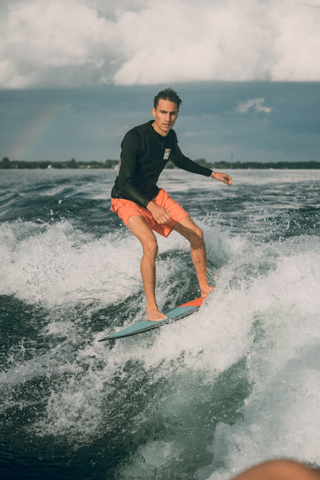 man with orange shorts wakesurfing
