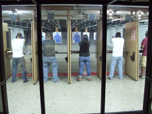 people lined up at shooting range following shooting range rules