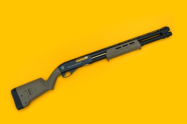 pump shotgun on yellow background