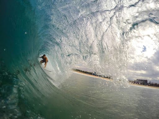 man surfing under wave