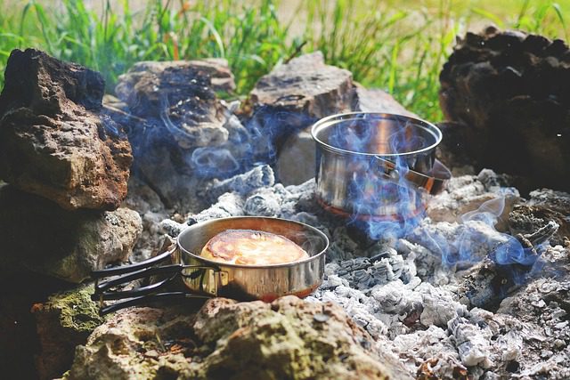 camping and cooking over a fire pots and pans