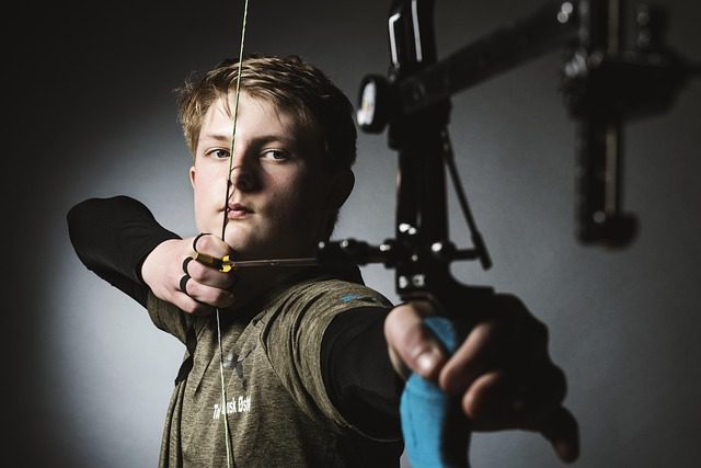youth at full draw with compound bow