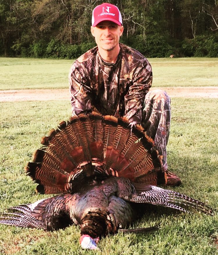 man wearing N1 Outdoors hat holding a turkey