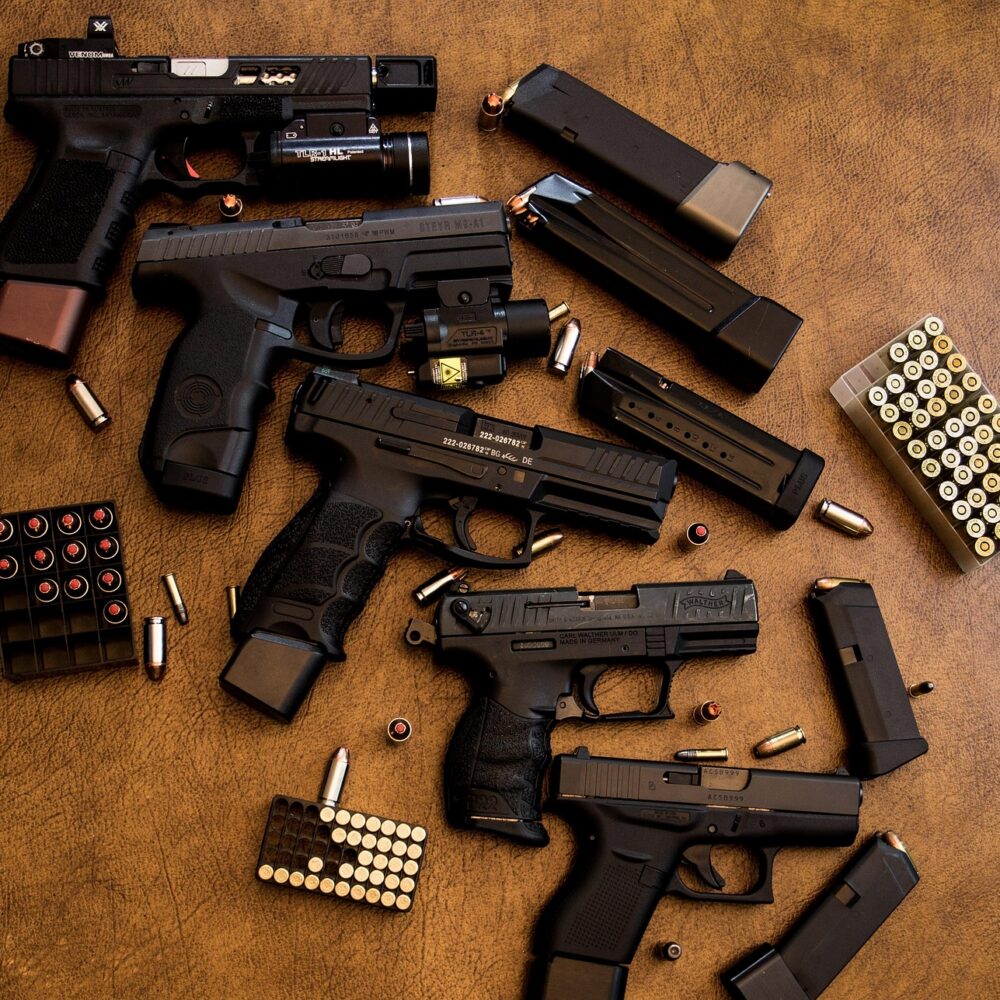 multiple hand guns and bullets on counter