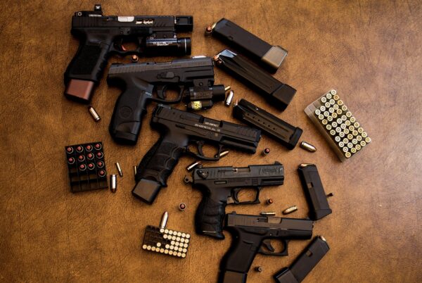 multiple hand guns and bullets on counter