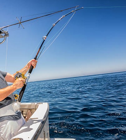 man holding fishing rod fishing offshore