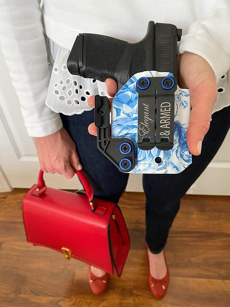 woman wearing red shoes and holding a gun in a holster