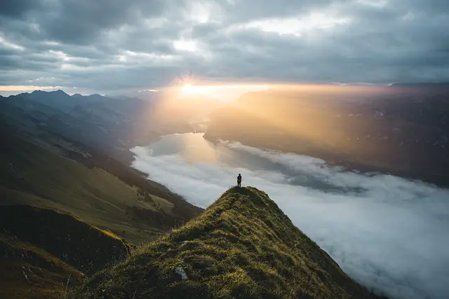 man on mountain viewing sunrise